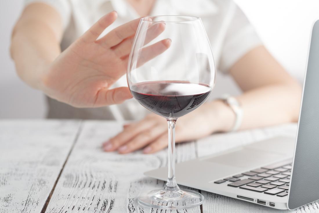 Woman saying no to a glass of red wine