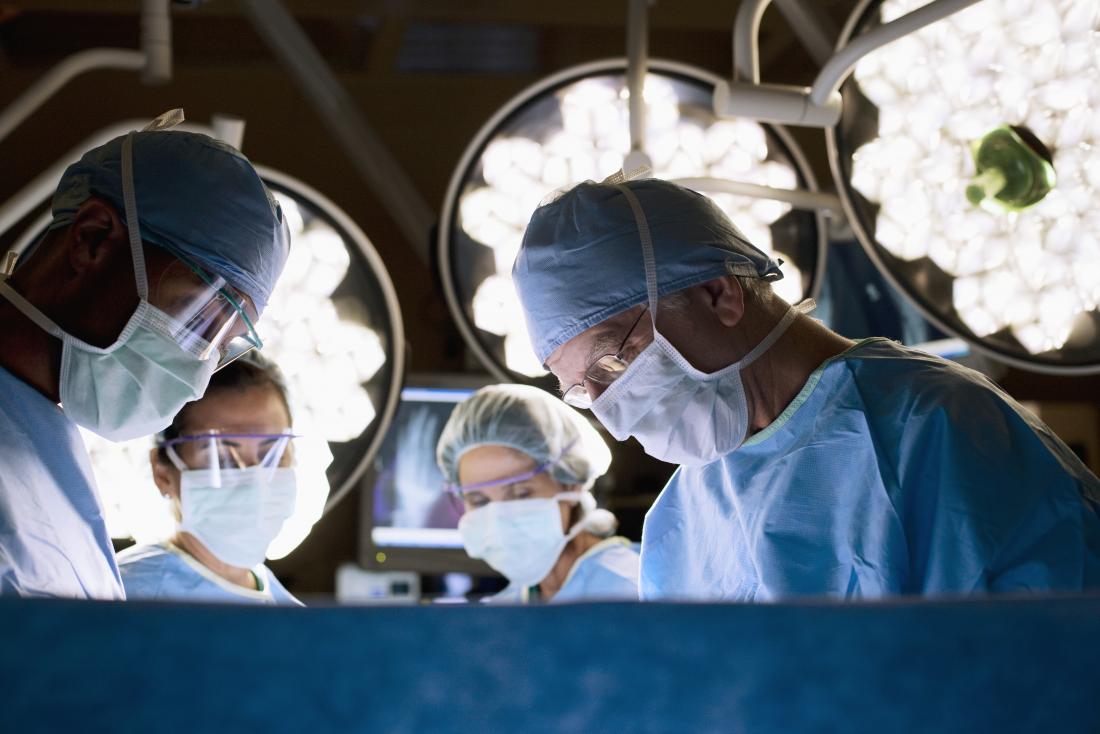 Surgeons performing thyroid removal surgery in operating theatre