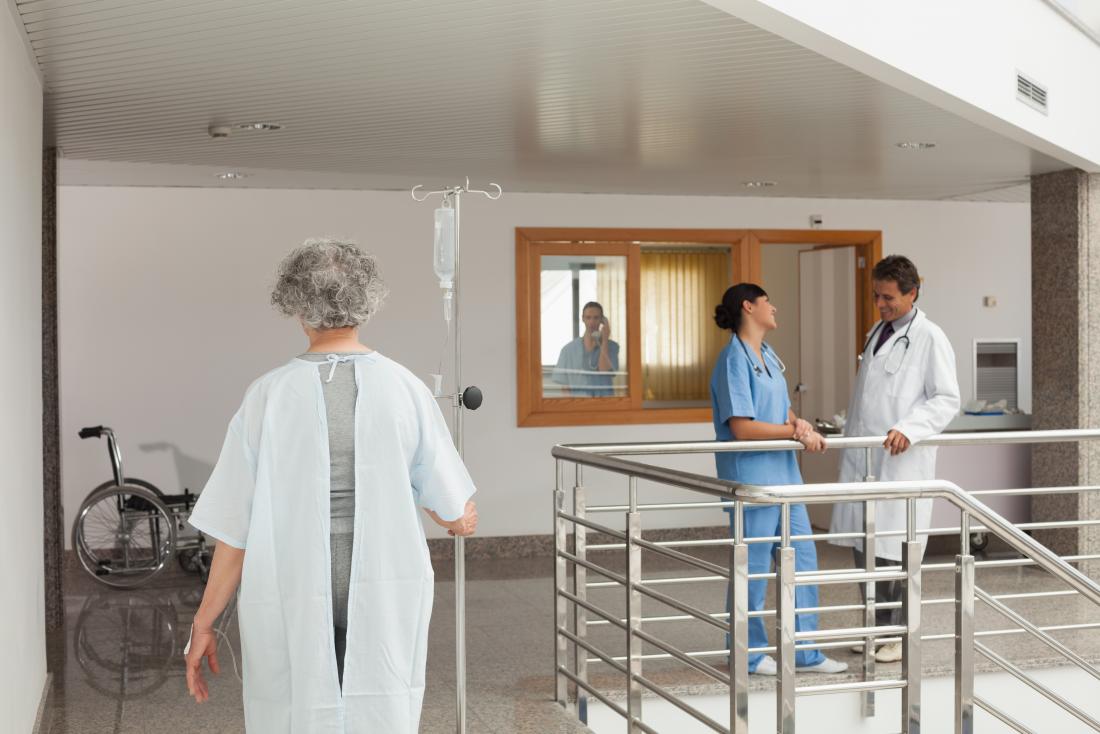female patient with drip walking in hospital