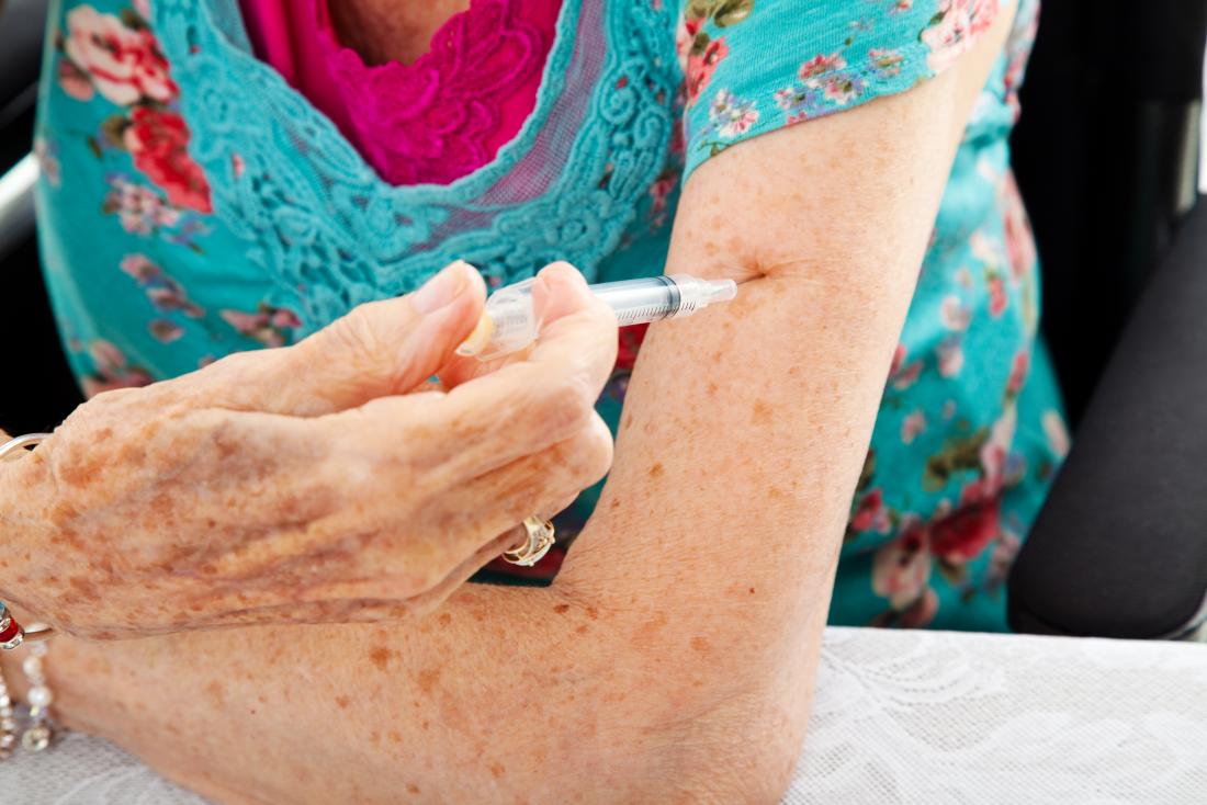 Senior woman using Enbrel or Humira injection to treat rheumatoid arthritis