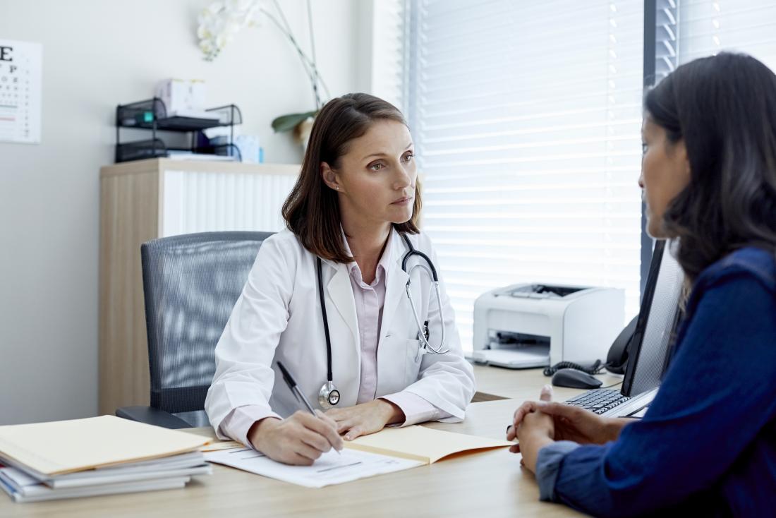 female doctor and patient discussing treatment and taking medical history