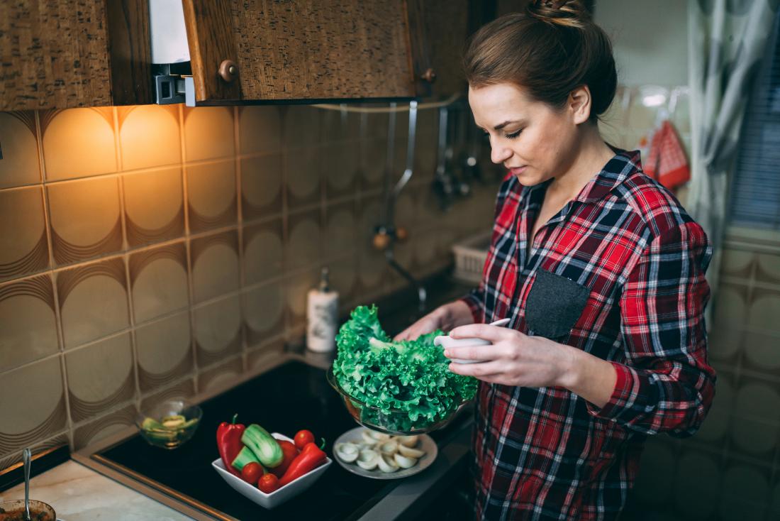 woman preparing salad in kitchen