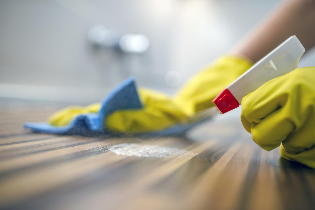 Person using cleaning products while wearing protective gloves