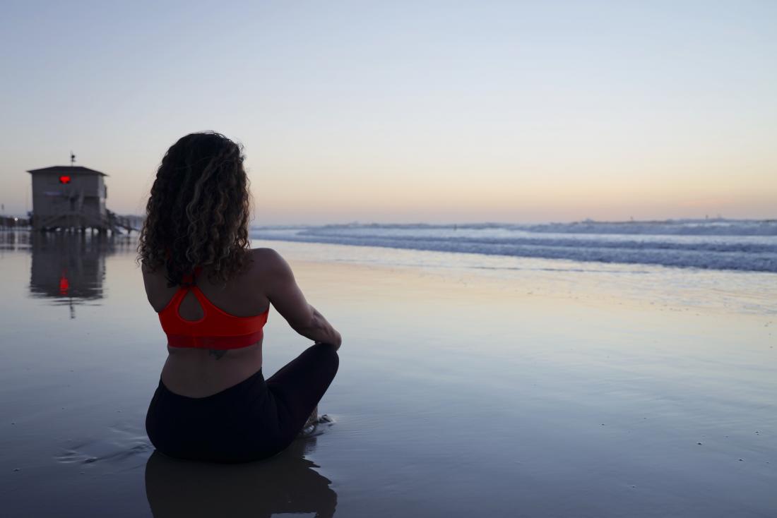 person meditating on the beach