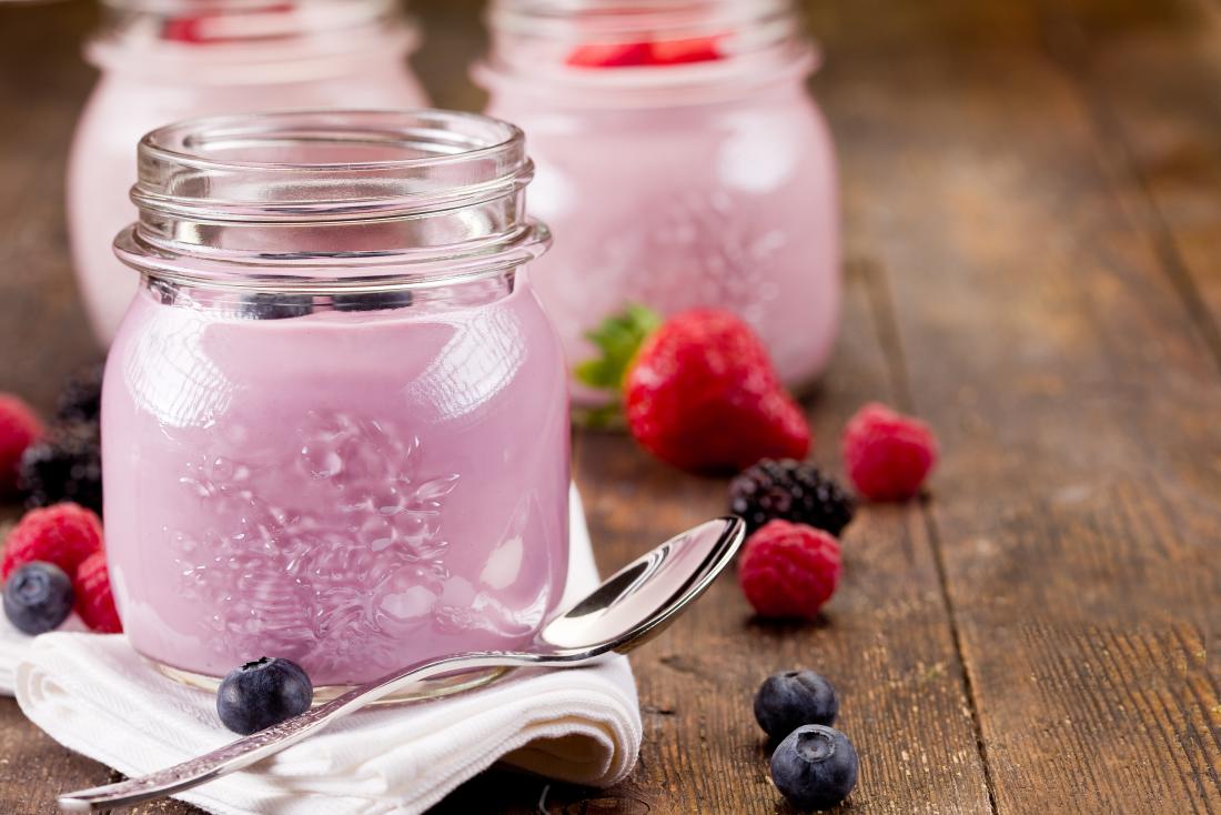 Flavored yogurt in jars with berries and fruit