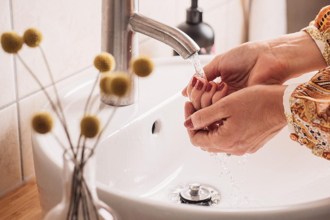 Woman washing her hands to stay healthy with a weak immune system