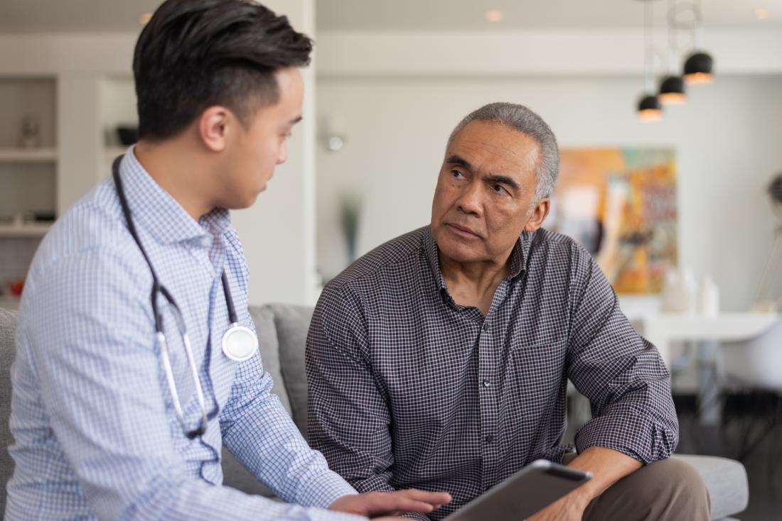 asian doctor talking to male patient
