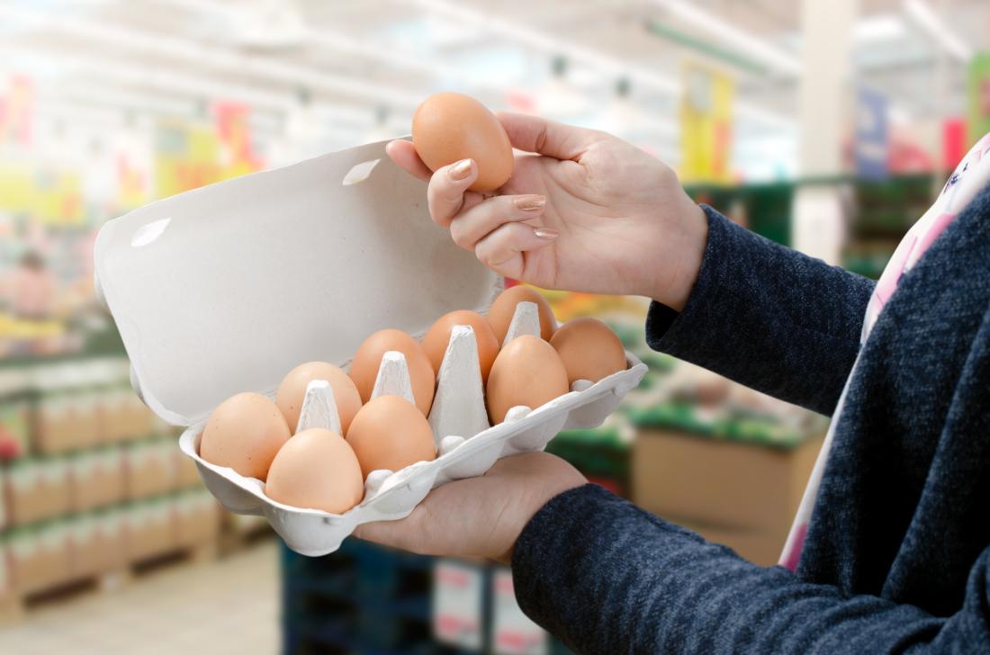 Woman holding an egg in a supermarket