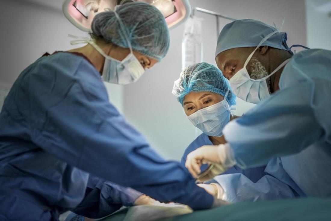 group of surgeons operating