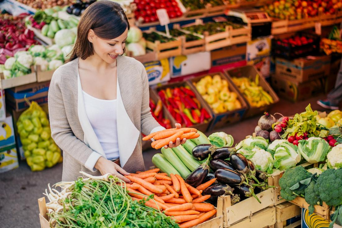 Woman shopping for fresh vegetables for a low protein diet