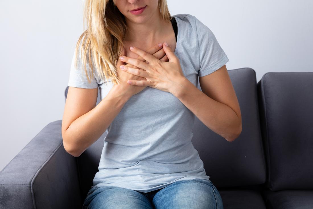 Woman holding her chest due to excessive burping