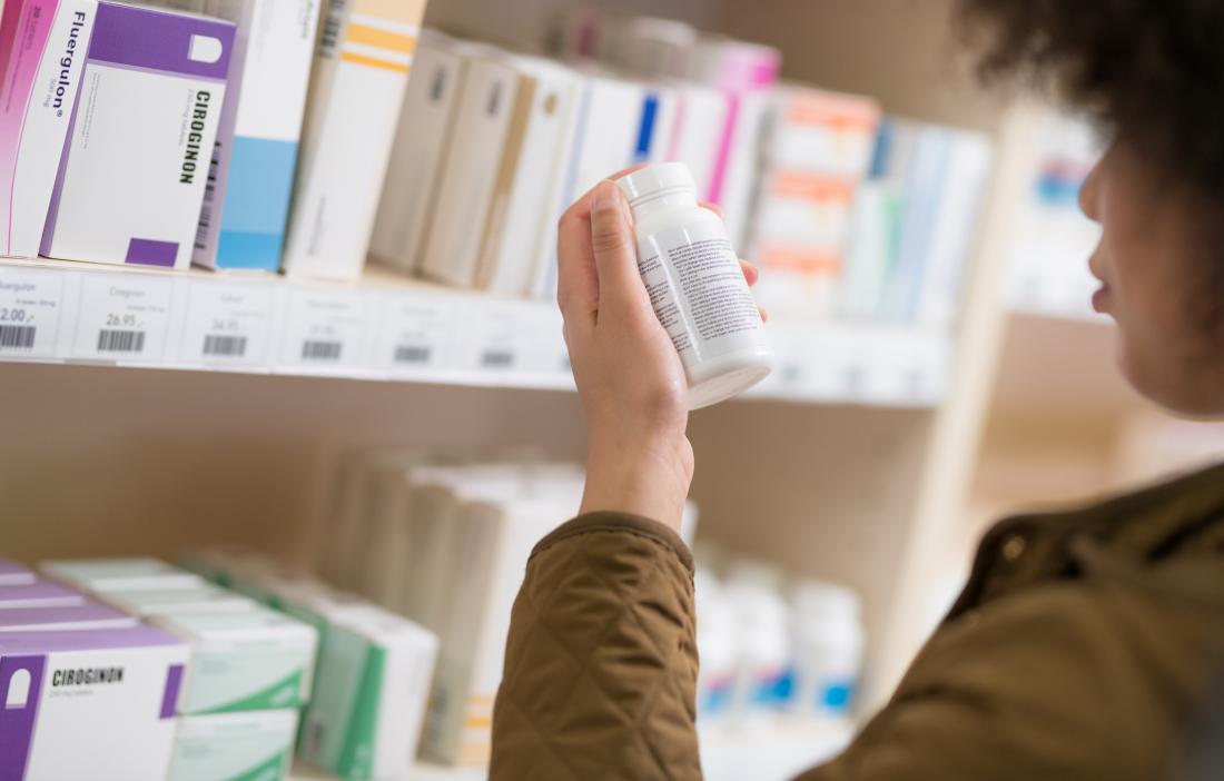 woman looking at bottle of pills