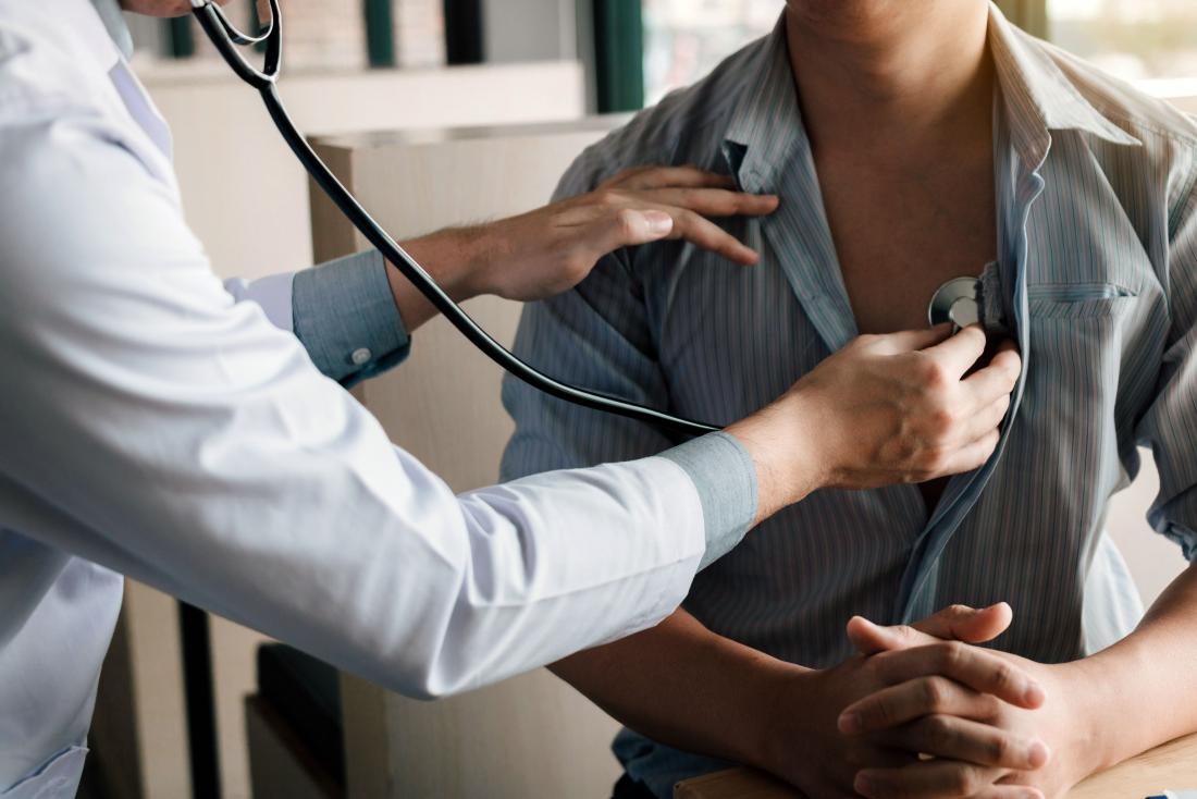 Doctor performs physical examination on patient with stethoscope.