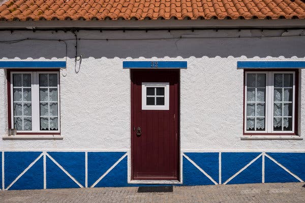 A brightly trimmed house on the main street of Porto Covo, a fishing village known for its beaches.