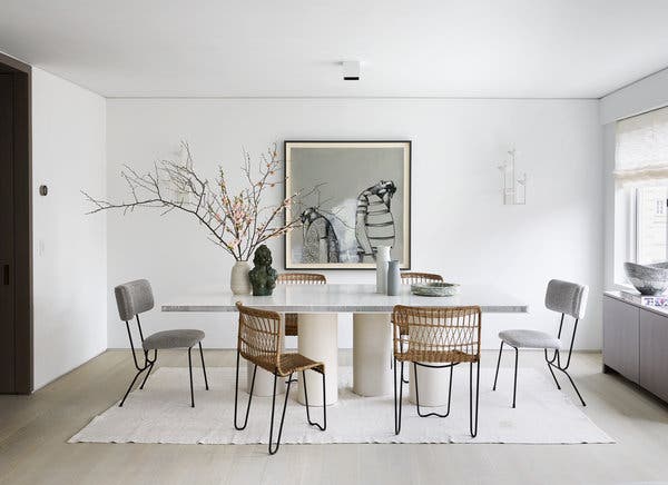 In the dining room, a custom table with plaster-column legs and a Corian-and-aluminum-honeycomb top is surrounded by vintage chairs the couple found at a Parisian flea market. The bust and painting are by George Condo.