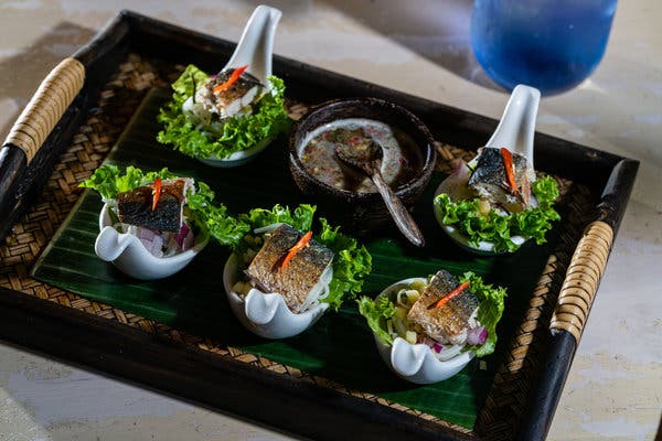 The miang pla too appetizer features silvery-skinned mackerel perched over a knot of rice noodles, cubed ginger, red onion, loose curls of lemongrass and threads of fresh chile.