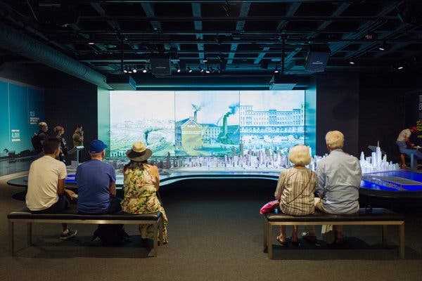 Visitors at the Chicago Architecture Center watch a multimedia presentation about the development of Chicago.