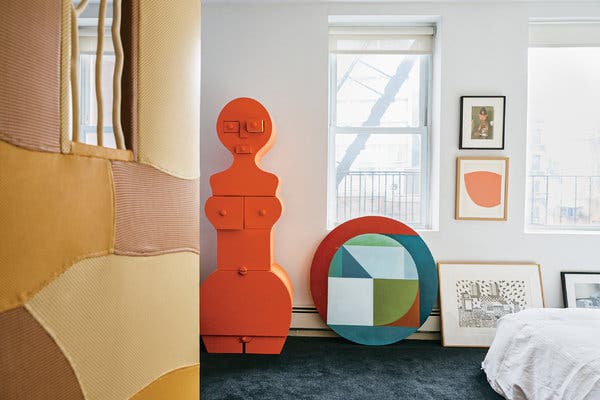 A leather-upholstered door by the artist Sam Stewart leads to the couple’s art-filled bedroom, where a photograph by Richard Kern and a print by Ellsworth Kelly hang above a painting by Chung Eun Mo and a drawing by Nathalie Du Pasquier. The orange commode is by Nicola L.