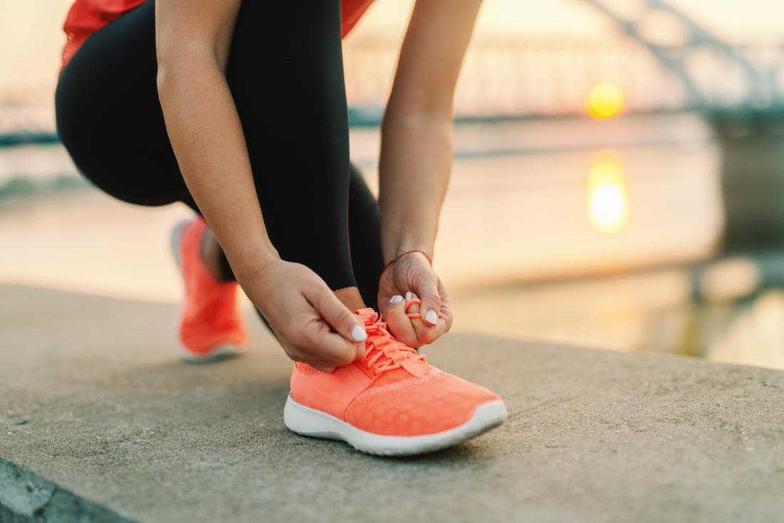 close up of woman tying her running shoes