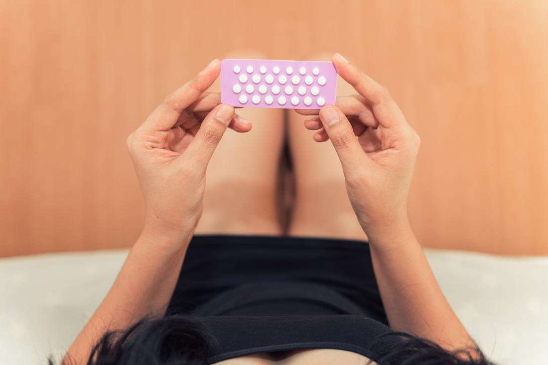 woman checking contraceptive pills