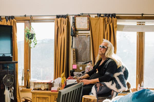 Duane Chapman, known as Dog, taking phone calls in the bedroom of his home in Pine, Colo.