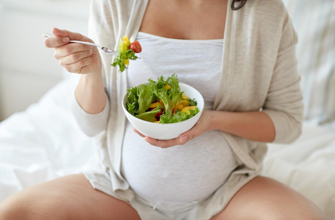 Pregnant woman eating healthful food