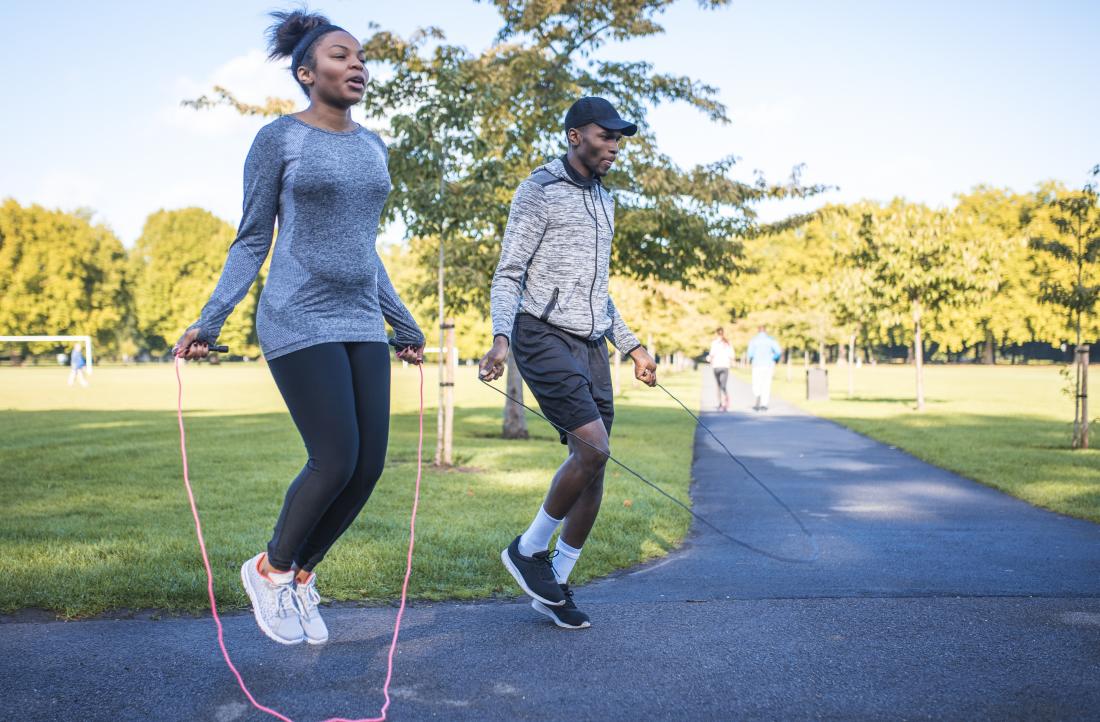 Two people in park jumping rope or using skipping rope for exercise