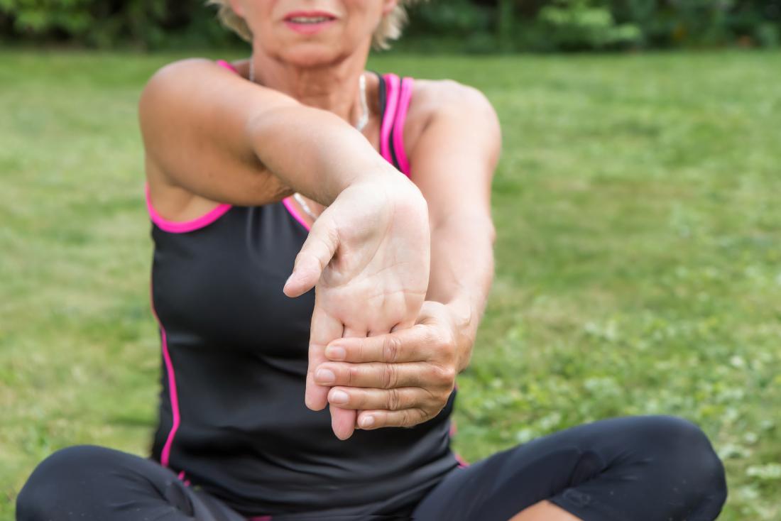 Woman performing wrist flexion stretches