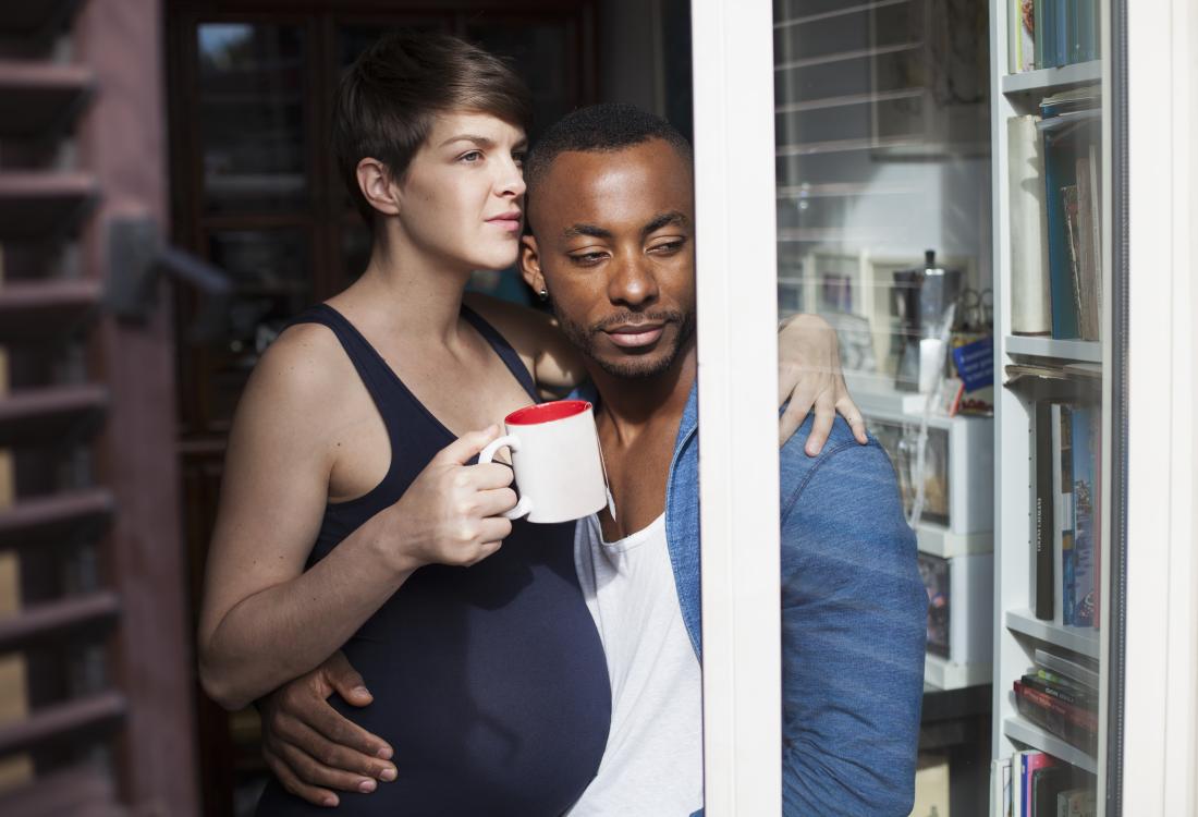 Pregnant woman embracing her partner