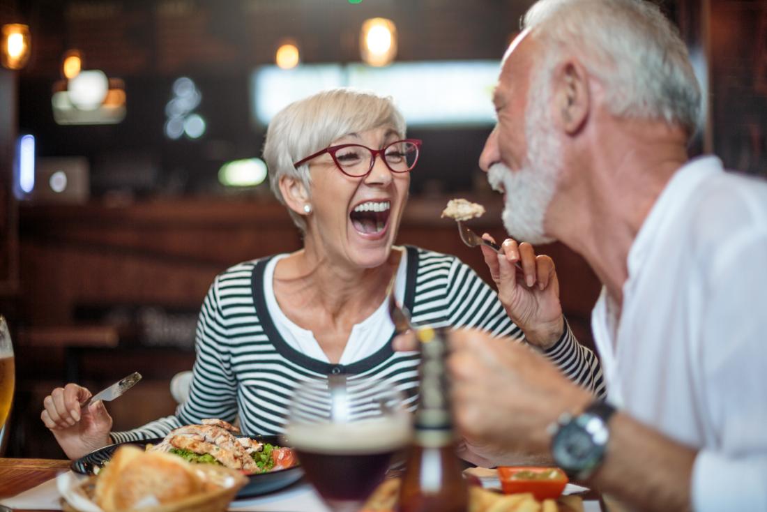 Older adults laughing and eating