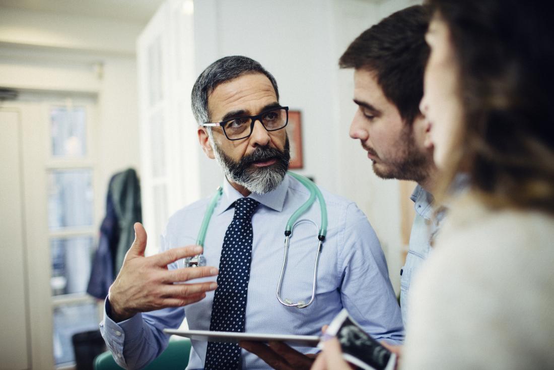 Doctor discussing something with patient couple in office