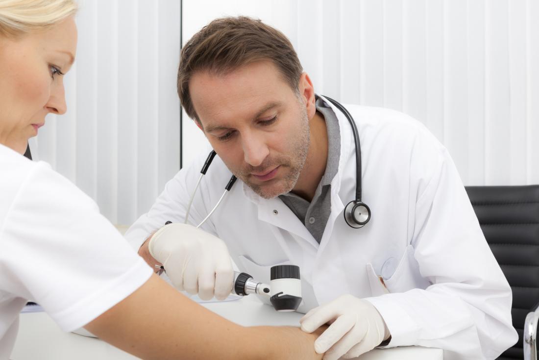 Dermatologist inspecting patients skin