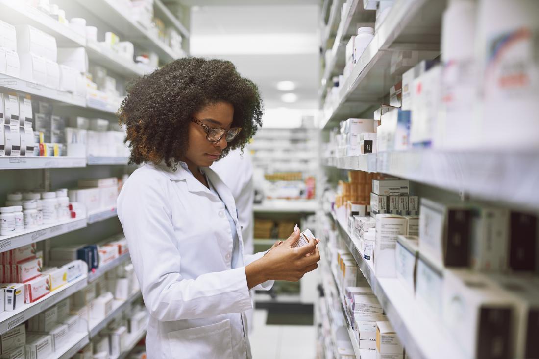 pharmacist looking at prescription medication in pharmacy