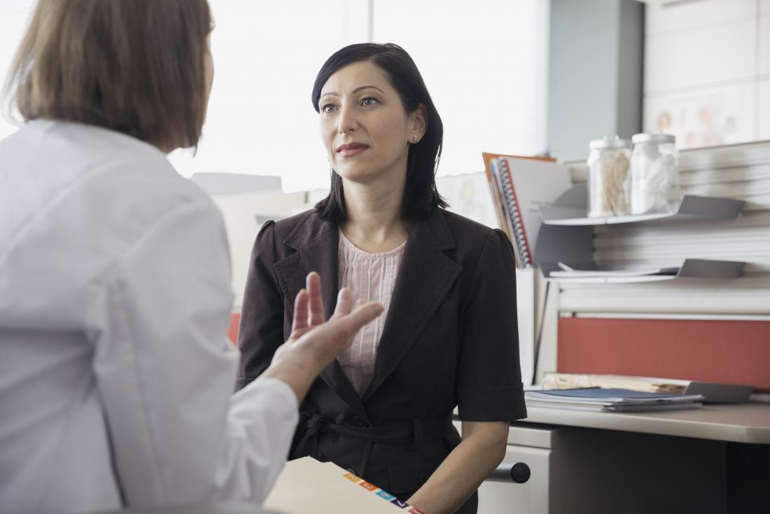Female patient listening to woman doctor in office