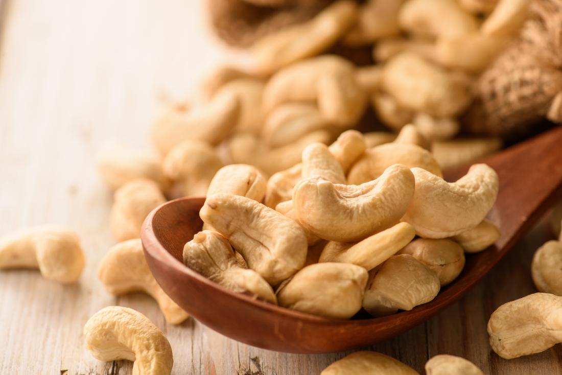 cashew nuts on wooden spoon