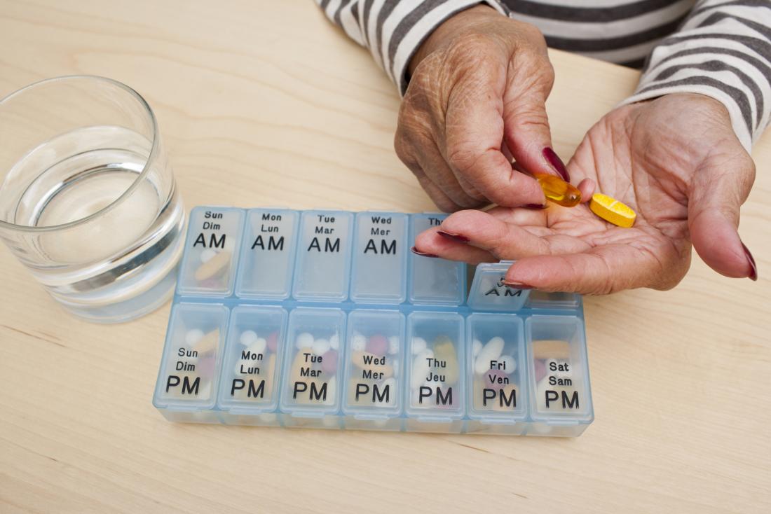 close up of senior woman's hands taking pills