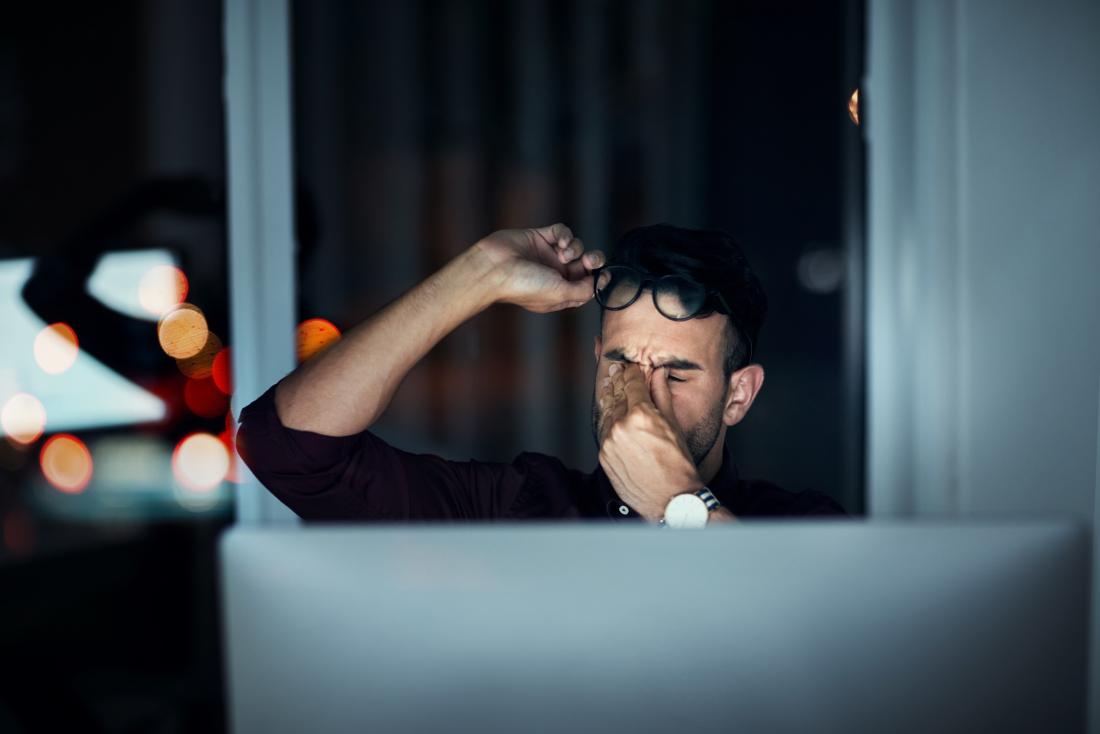 man looking tired in front of their computer