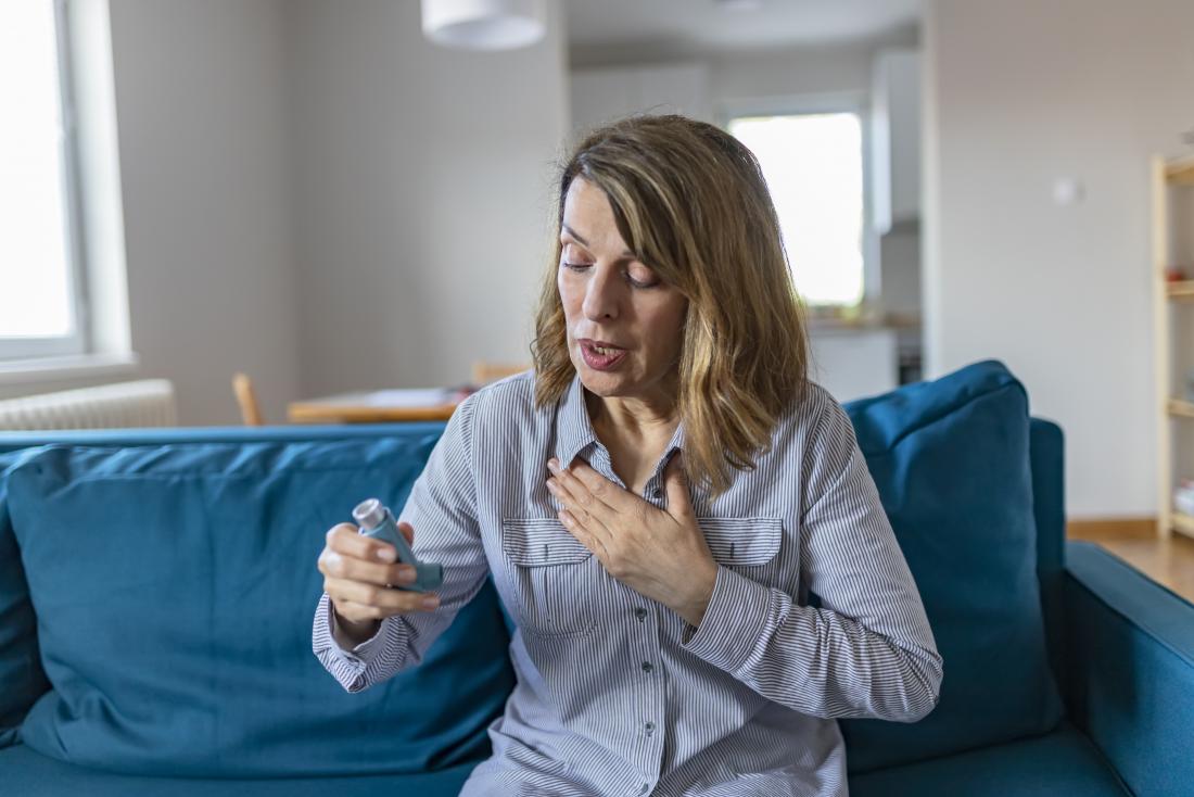 Woman with severe asthma using inhaler