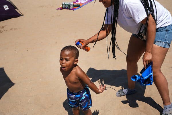 Hendrixx Love, 1, reacted as he got sprayed with sunscreen by his mother, Ashley Love, 23, at Coney Island Beach. 