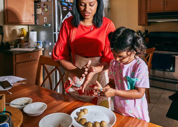 Ms. Vasavada making peanut laddoos coated in chocolate with her daughter, Elara.