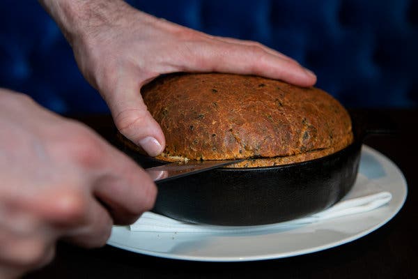 Slicing open a loaf of seaweed bread reveals something baked inside: a whole sweet potato.