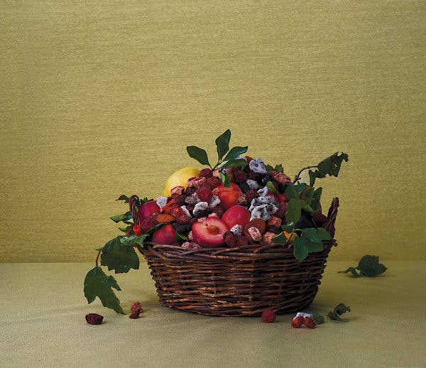 A crack-seed-and-stone-fruit basket, featuring red sweet li hing mui, li hing cherry, seedless peach, dry red salty mango seed, juicy whole lemon, red li hing mui, sweet-sour li hing mui, lemon balls and white mountain plum.