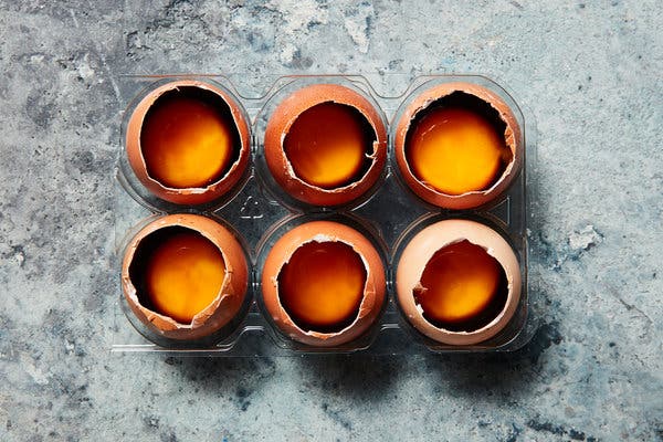 Raw egg yolks curing with a splash of soy sauce, which firms up the yolks and imparts deep flavor. The soy-cured yolks become a rich garnish for arroz caldo.