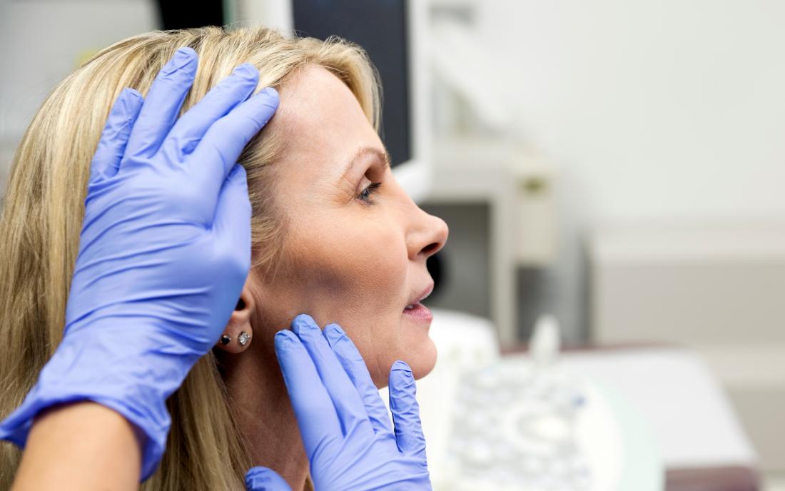 a doctor inspecting a dent in a womans head 
