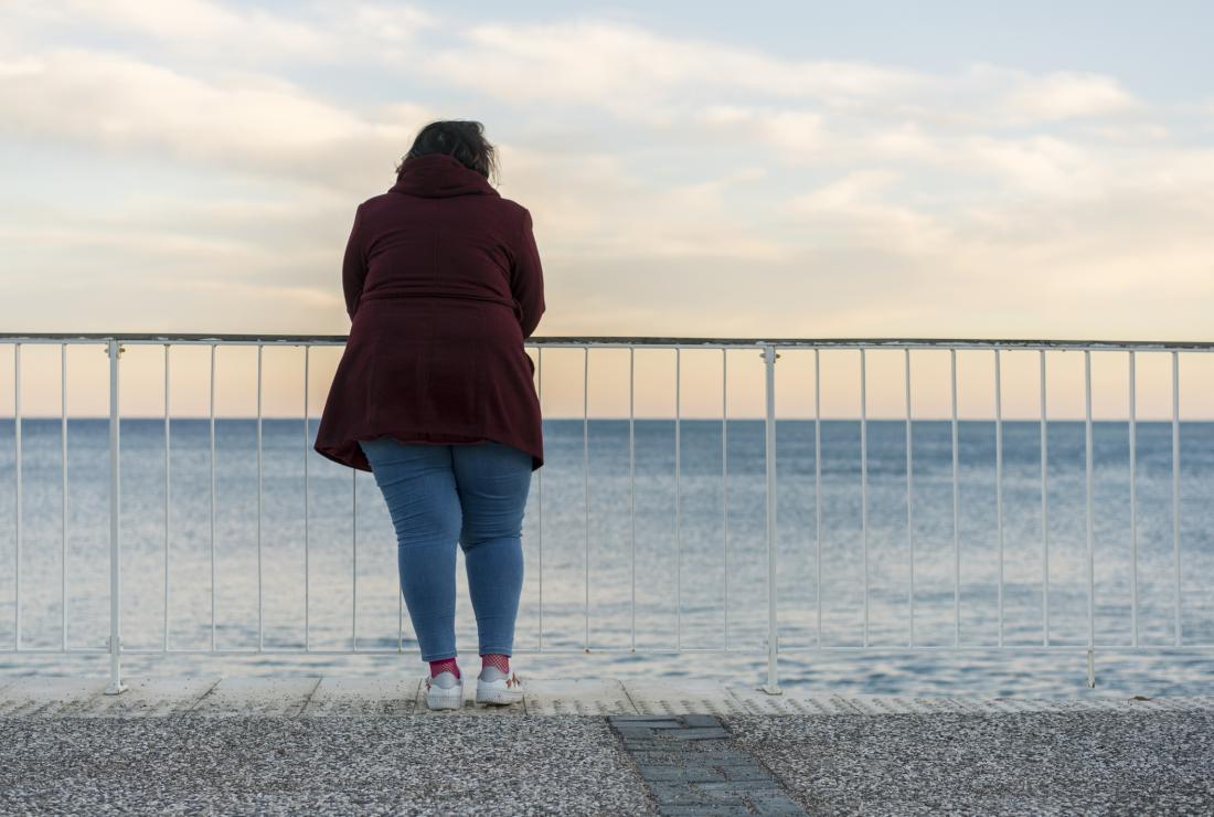 obese woman looking at the sea