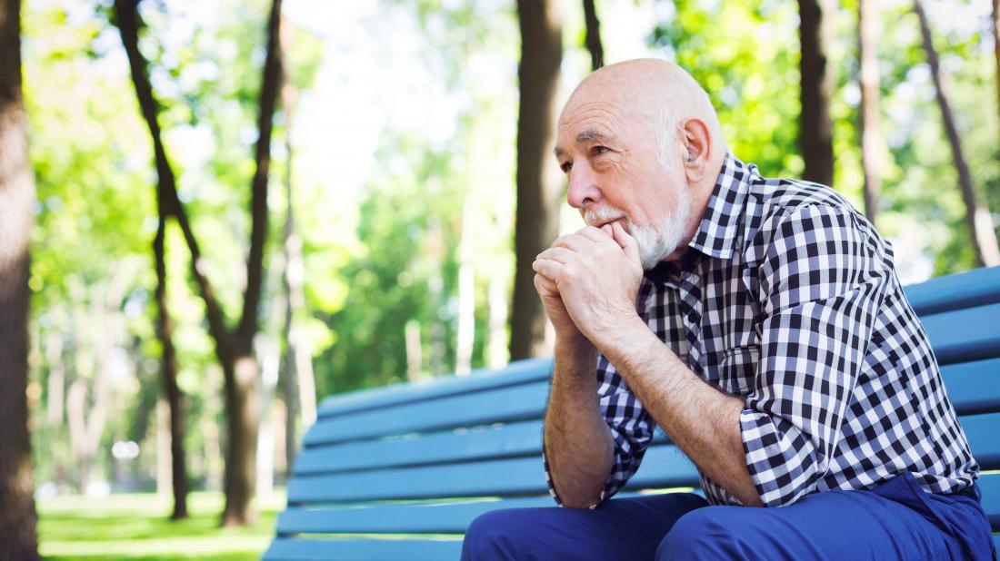 a man with Diabetes and anxiety sat looking pensive on a park bench