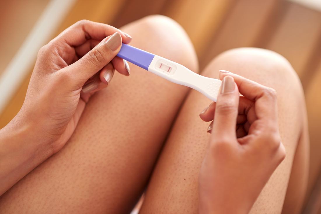 a woman checking a HCG pregnancy test