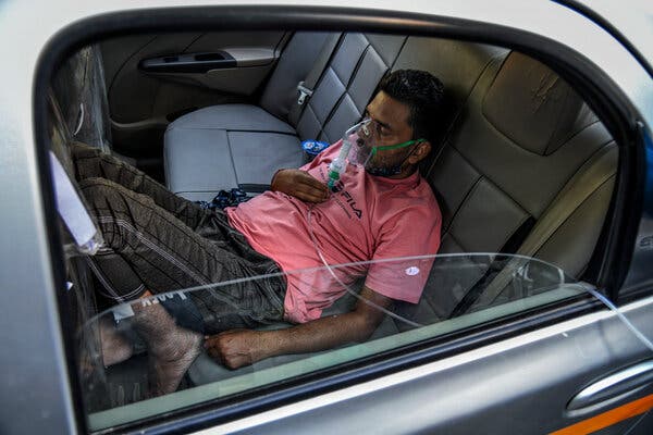 A coronavirus patient in New Delhi receiving oxygen in a car on Sunday.