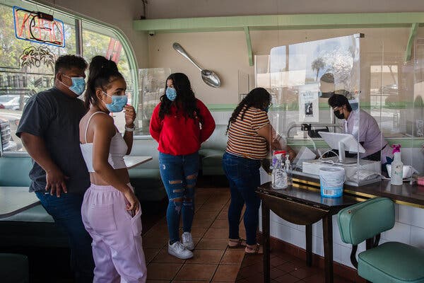 Customers donning masks to pay their bill at a cafe in San Diego, California, on Tuesday.