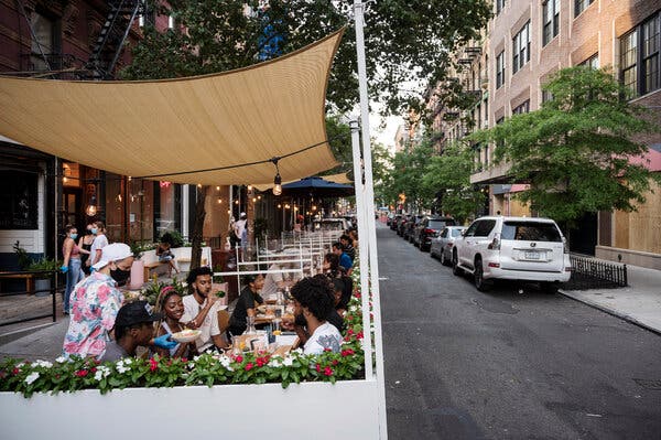 People dining outdoors at a restaurant in Manhattan in July. New Yorkers will soon be able to drink at bars and restaurants without the requirement of ordering food.
